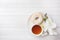 Cup of tea and donuts, white orchid on white table with copy space. Flat lay, top view