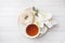 Cup of tea and donuts, white orchid on white table with copy space. Flat lay, top view