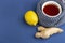 Cup of tea, ginger, lemon as folk remedies on blue background  with copy space for text. The concept of seasonal diseases and