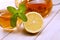 Cup of tea, glass teapot, mint and lemon on wooden table