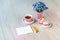 A cup of tea with heart shaped macarons, bouquet of forget-me-not flowers and card for congratulation text on a table.