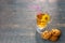 Cup of tea with herbal tea, yellow dandelion and pink straw and cookies with raisins on blue wooden background