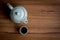 A cup of tea and kettle on rustic wood background