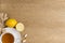 Cup of tea, lemons, ginger and multivitamin supplements pills on wooden background. Top view. Flat lay. Copy space for