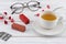 A cup of tea, lipsticks, necklace and eyeglasses