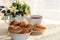 A cup of tea and mini croissants on a sunny table with selective focus, a bouquet of spring