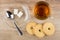 Cup with tea, spoon and lumpy sugar in saucer, cookies