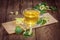 Cup of tea, standing on a wooden table, surrounded by fragrant linden flowers