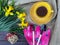 A Cup of tea stands on a table with yellow flowers daffodils and gardening tools.