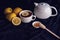 Cup of tea and teapot with lemons and honey on a dark background