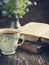 Cup of tea, vintage books and summer flowers on the table.