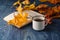 Cup of tea wit old book and autumn leaves on wooden table