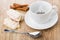 Cup with teabag, cinnamon, teaspoon, glazed cookies on wooden ta