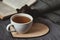 Cup of tean and teapot on wooden heart book and scarf on background