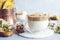 Cup of Trendy whipped cream cold dalgona coffee and Italian biscotti on light grey background
