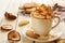 Cup of whipped cream coffee and apple cookies on wooden table