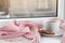 Cup of winter drink, cookies and knitted scarf on windowsill