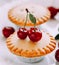 Cupcake with cherries on white wooden boards.