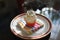 Cupcake or cup cake with whipped cream and small colorfull sugar perils served on the small dessert plate with paper napkin and re