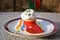 Cupcake or cup cake with whipped cream and small colorfull sugar perils served on the small dessert plate with paper napkin and re