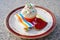 Cupcake or cup cake with whipped cream and small colorfull sugar perils served on the small dessert plate with paper napkin and re