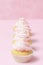 Cupcake decorated with pink buttercream on pastel pink background. Sweet beautiful cake. Vertical banner, greeting card for birthd