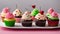 cupcake with icing and sprinkles A festive photo of four decorated cupcakes on a white plate. The cupcakes are in different colors