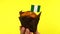 Cupcake with Nigerian flag on male palm against yellow background