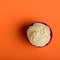 Cupcake in purple wrap on coral colour background. Minimalist. Top view with copy space