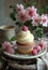 Cupcake with raspberry on plate. A small cupcake sits beside some tea and flowers