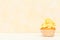Cupcake with yellow cream decoration on yellow background - pastel horizontal banner. Minimalism still life concept.