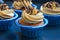Cupcakes in blue molds capsules with different creams