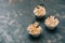 Cupcakes with cream sprinkled with nuts on a gray blue background. Copy space.
