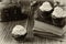 Cupcakes in paper patty cases, antique books, chest, walnut shells. Black-and-white photo effect.