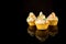 Cupcakes, three cupcakes with colorful sprinkles on black background with reflections, copy space