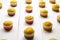 Cupcakes on white background, selective focus. Rows of muffins on wooden table, closeup. Homemade bakery