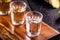 cups of cachaÃ§a, with sugar cane in the background, a Brazilian