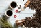 Cups with coffee, cezve coffee grains,heather, hearts scattered on a light wooden background. Top view