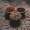 Cups of coffee among selected and calibrated Arabica coffee beans scattered on a black background.