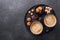 Cups of coffee, various sweets and spice on ceramic plate. Top view. Copy space