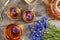 Cups of herbal tea, transparent teapot and blue cornflowers flowers on wood background. Top view Flat lay