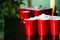 Cups and plastic ball for beer pong game on table