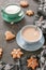 Cups with tea blue and green. On a gray concrete background. Next to them are Christmas cookies and woolen cloth. Vertical photo.