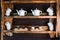 Cups and teapots for tea on a beautiful wooden shelf.