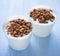 Cups of yogurt with cereals on blue background