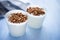 Cups of yogurt with cereals on blue background