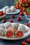 Curd balls with coconut shavings, strawberries and chocolate chip cookies located on a dark background, vertical