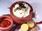 Curd rice in a clay pot with lemon pickle and ingredients