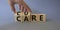 Cure and Care symbol. Businessman hand turnes wooden cubes and changes words Care to Cure. Beautiful grey background. Business and