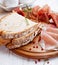 Cured dry ham and bread on wooden board